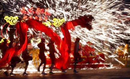Dancers perform a fire dragon dance in the shower of molten iron spewing firework-like sparks during a folk art performance to celebrate the traditional Chinese Spring Festival on the first day of the Chinese Lunar New Year, which welcomes the Year of the Horse, at the Happy Valley amusement park in Beijing January 31, 2014. REUTERS/Kim Kyung-Hoon (CHINA - Tags: ANNIVERSARY SOCIETY TPX IMAGES OF THE DAY) ORG XMIT: PEK720